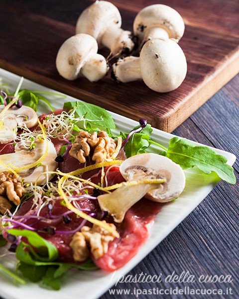 carpaccio-di-vitello con funghetti sullo sfondo